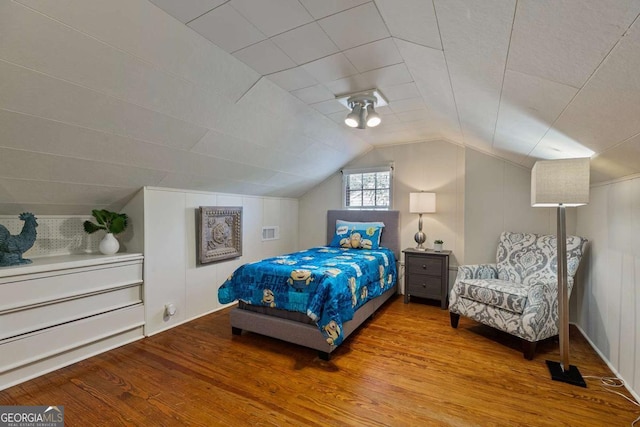 bedroom with wood-type flooring and vaulted ceiling