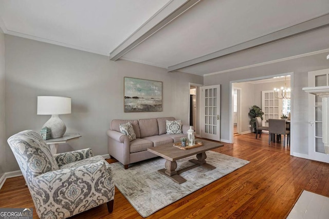 living room with french doors, wood-type flooring, ornamental molding, a notable chandelier, and beamed ceiling