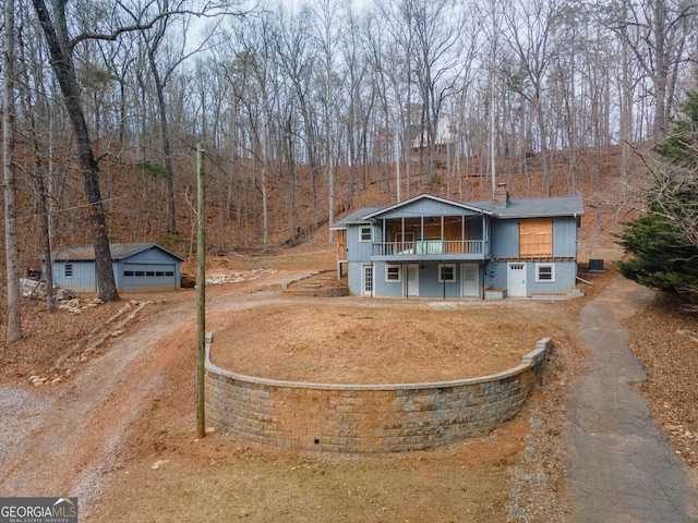 view of front of house featuring a garage and an outbuilding