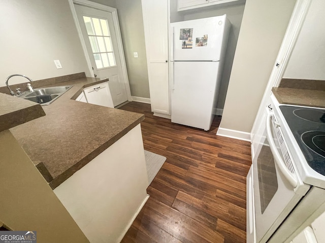 kitchen with dark hardwood / wood-style floors, white cabinetry, sink, kitchen peninsula, and white appliances