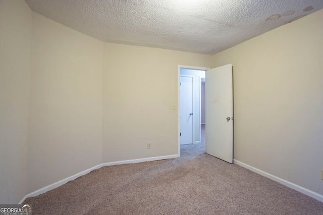 carpeted spare room featuring a textured ceiling