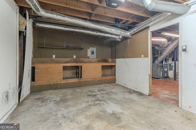 basement featuring heating unit and electric panel