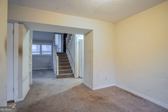 interior space with carpet floors and a textured ceiling