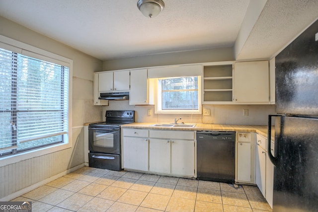 kitchen with sink, black appliances, a textured ceiling, light tile patterned floors, and white cabinets