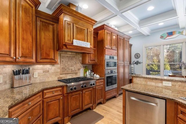 kitchen featuring coffered ceiling, light stone counters, stainless steel appliances, beam ceiling, and backsplash