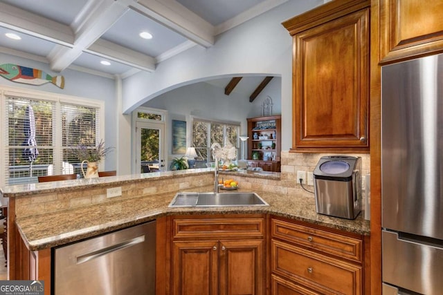 kitchen with stainless steel appliances, sink, beamed ceiling, and kitchen peninsula