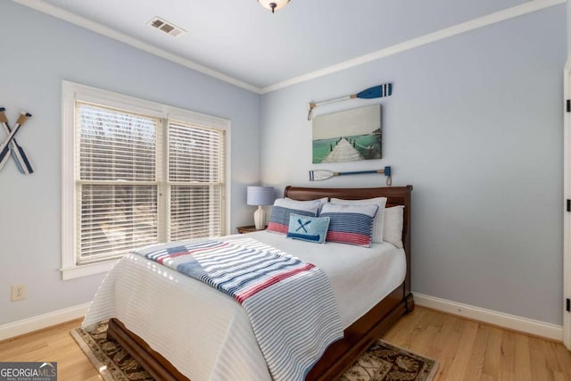 bedroom featuring crown molding and light wood-type flooring