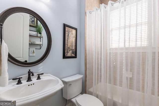 full bathroom featuring shower / bath combination with curtain, toilet, and sink