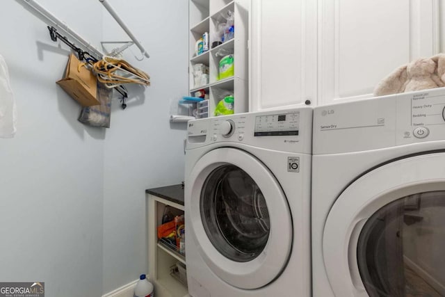 washroom featuring cabinets and washing machine and clothes dryer