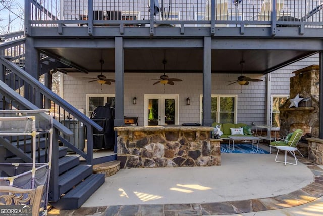 view of patio / terrace with a bar, ceiling fan, and a balcony