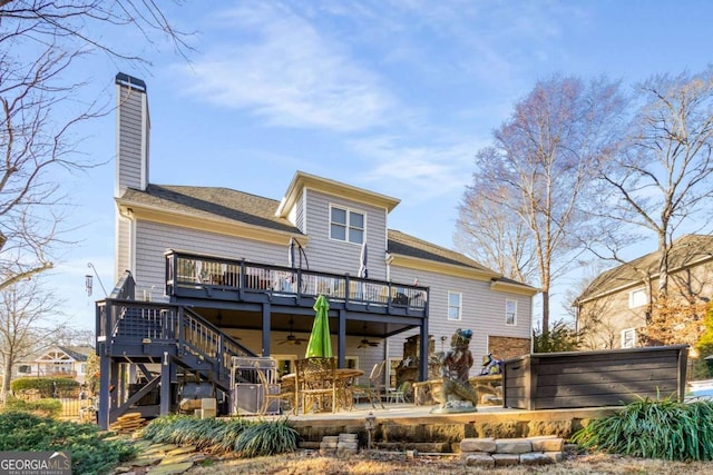 rear view of property featuring a wooden deck, a hot tub, and a patio