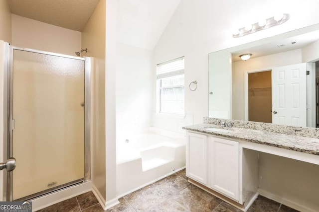 bathroom featuring vanity, shower with separate bathtub, tile patterned flooring, and vaulted ceiling