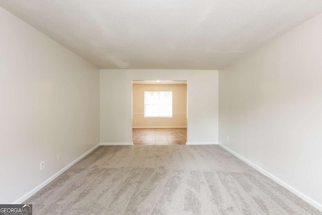 carpeted empty room with a textured ceiling