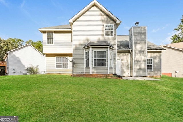 rear view of house featuring a yard