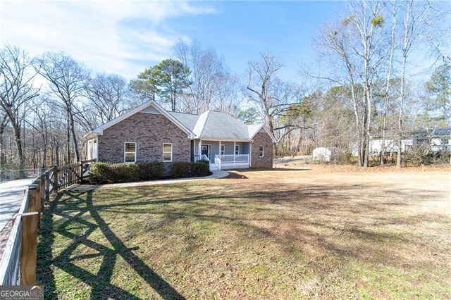 4801 Daniel Mill Rd, Winston, GA 30187 - view of front of house featuring a front yard, fence, covered porch, and brick siding
