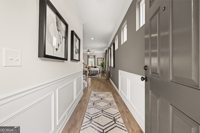 hall with crown molding and light hardwood / wood-style flooring