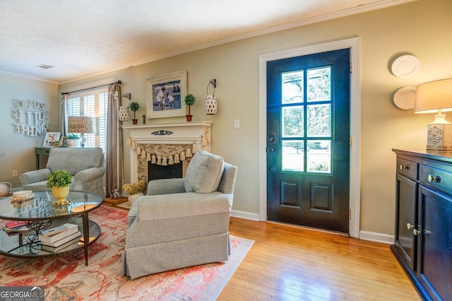 interior space featuring ornamental molding, a fireplace, and light hardwood / wood-style flooring