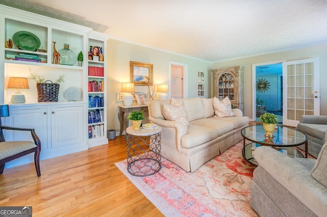 living room with ornamental molding and light hardwood / wood-style flooring