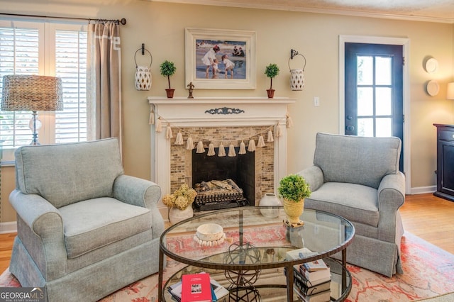 sitting room with hardwood / wood-style flooring, a fireplace, and ornamental molding