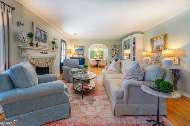 living room featuring hardwood / wood-style flooring, crown molding, and a notable chandelier