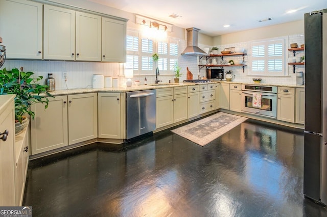 kitchen with sink, extractor fan, cream cabinetry, stainless steel appliances, and backsplash