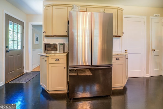 kitchen featuring appliances with stainless steel finishes, dark hardwood / wood-style floors, light stone counters, and cream cabinetry