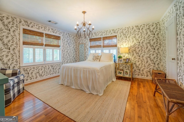 bedroom with hardwood / wood-style flooring, crown molding, and multiple windows