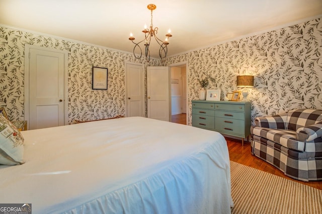 bedroom with dark hardwood / wood-style floors and a notable chandelier