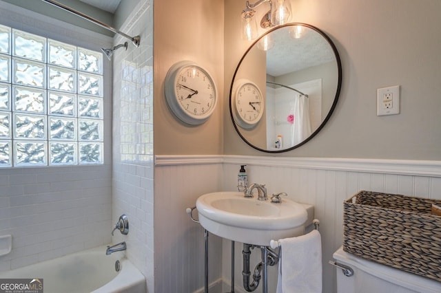 full bathroom with sink, tiled shower / bath combo, and toilet