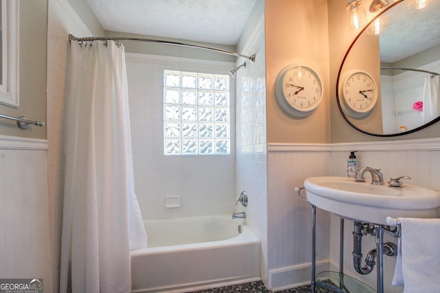 bathroom featuring shower / bath combination with curtain and a textured ceiling