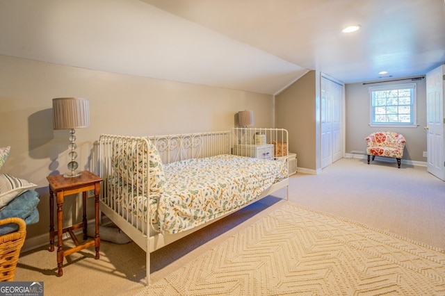 bedroom featuring light colored carpet and vaulted ceiling