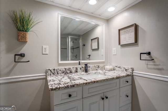 bathroom featuring vanity, crown molding, and walk in shower