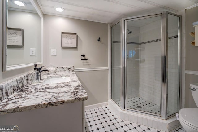 bathroom with vanity, an enclosed shower, ornamental molding, and toilet