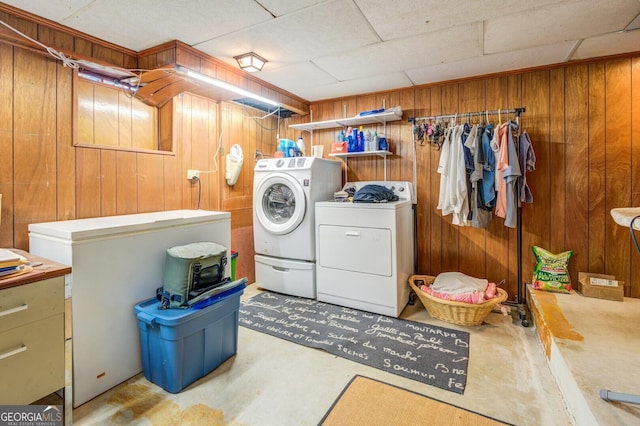 laundry room with separate washer and dryer and wooden walls