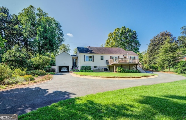 split foyer home with a deck and a front lawn