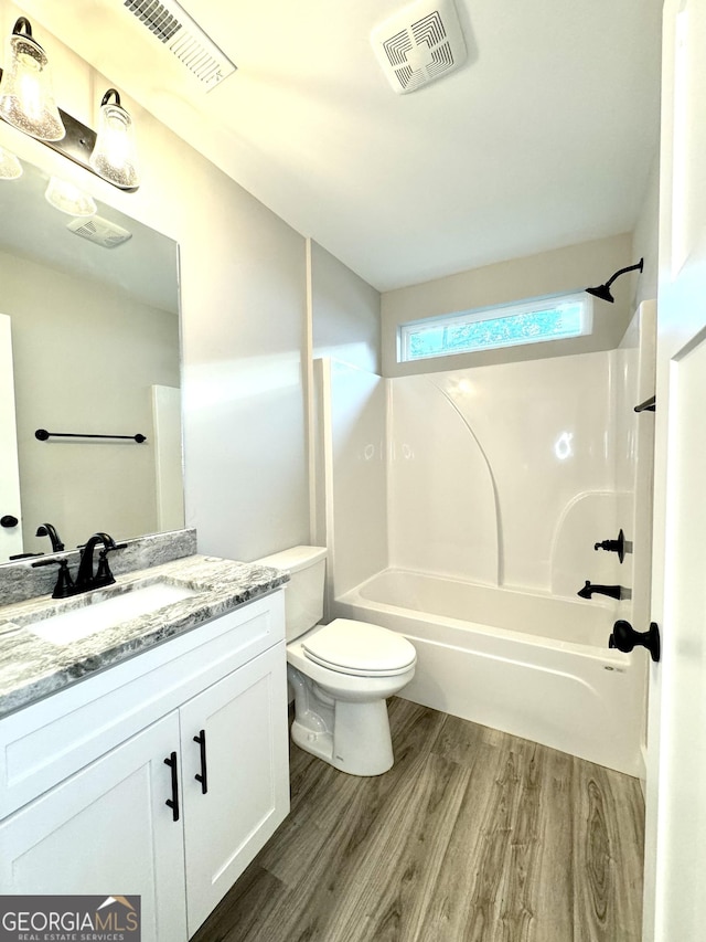 full bathroom featuring vanity, hardwood / wood-style flooring, toilet, and shower / bath combination