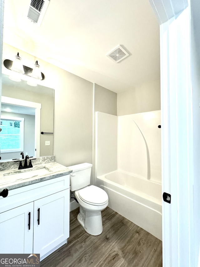 full bathroom featuring vanity, wood-type flooring, shower / bathtub combination, and toilet