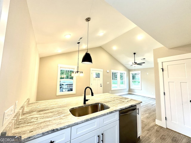 kitchen featuring black dishwasher, sink, light stone countertops, and white cabinets