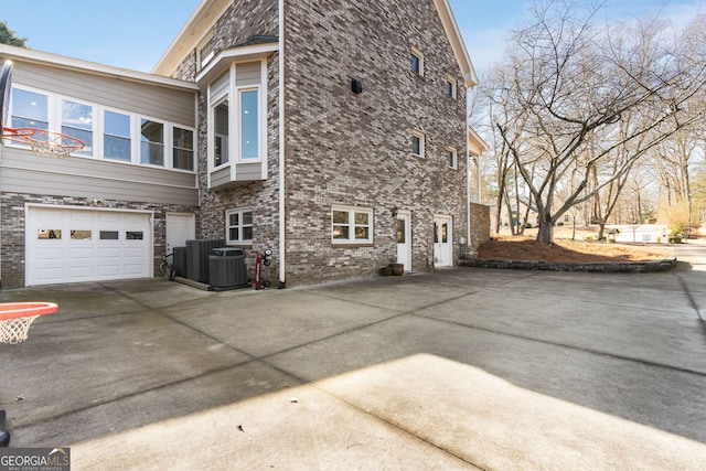 view of side of home featuring central AC unit and a garage