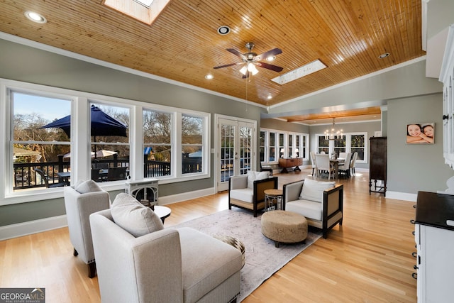 living room with lofted ceiling with skylight, wood ceiling, crown molding, light hardwood / wood-style flooring, and ceiling fan with notable chandelier