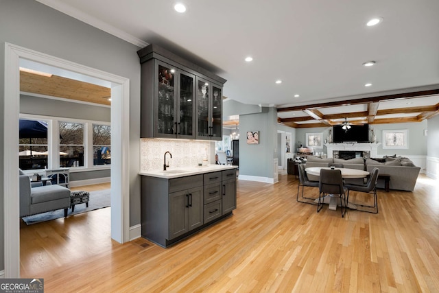 kitchen with gray cabinetry, decorative backsplash, coffered ceiling, light hardwood / wood-style floors, and beam ceiling