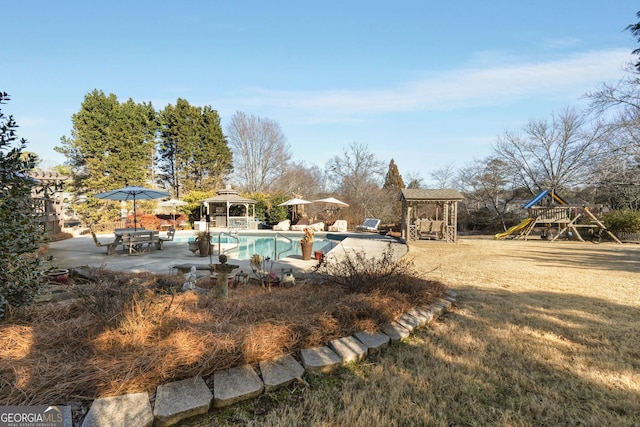 view of pool with a playground and a gazebo