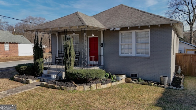 bungalow-style house with covered porch and a front lawn