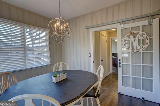 dining space with dark wood-type flooring and an inviting chandelier