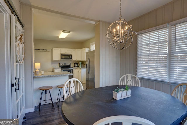 dining area with dark hardwood / wood-style flooring and a chandelier