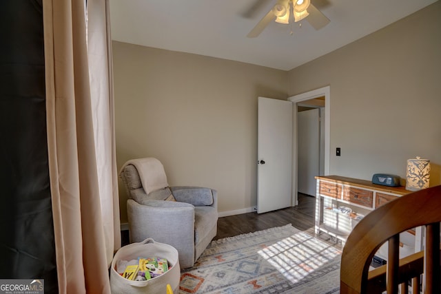 living area with dark hardwood / wood-style flooring and ceiling fan