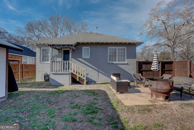 rear view of property with an outdoor living space with a fire pit and a patio area