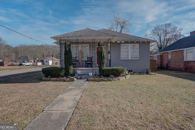 bungalow-style house with covered porch and a front lawn