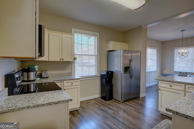 kitchen with pendant lighting, range with electric stovetop, white cabinets, and stainless steel refrigerator with ice dispenser