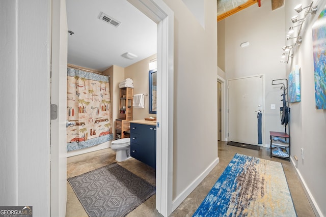 bathroom with vanity, curtained shower, and toilet